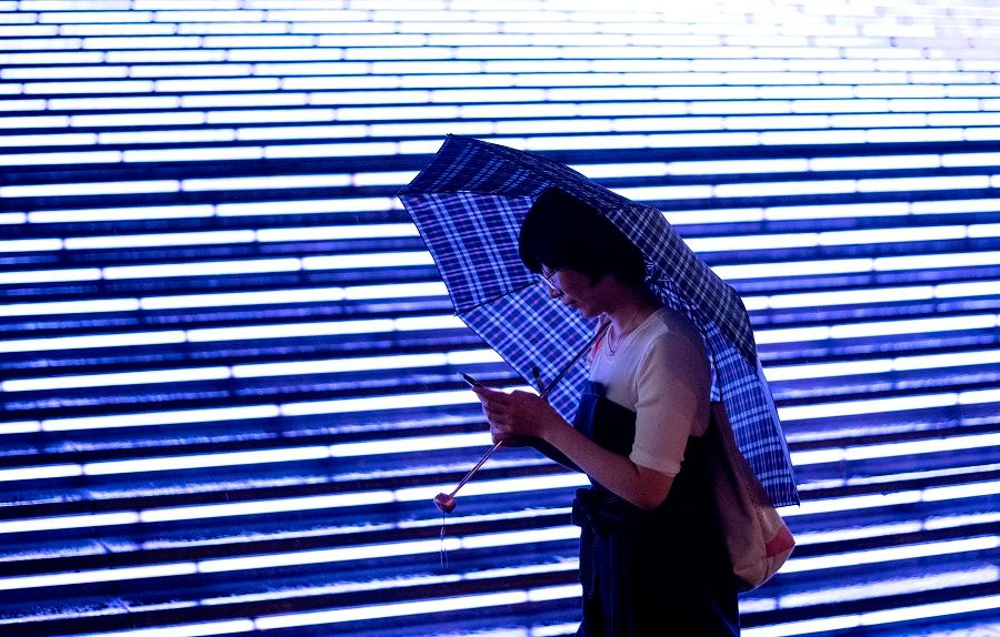 A woman uses her mobile phone at a mall in Beijing on 18 August 2020. (Noel Celis/AFP)