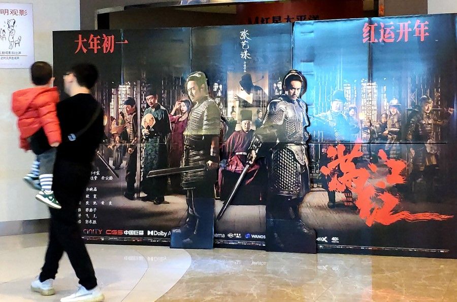 A man and a child walk past a display for Full River Red in a cinema in Fuzhou, 25 January 2023. (CNS)