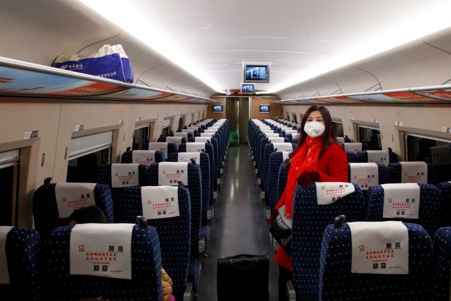 A woman rides the high-speed train near Jiujiang, Jiangxi province, 29 January 2020. (Thomas Peter/Reuters)