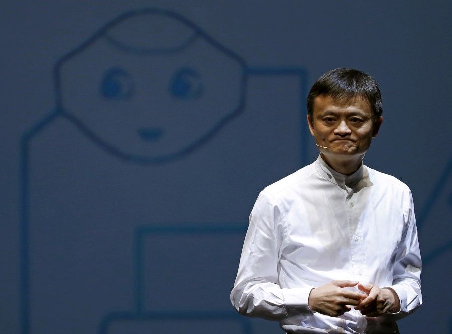 Jack Ma, founder and executive chairman of China's Alibaba Group, speaks in front of a picture of SoftBank's human-like robot named 'Pepper' during a news conference in Chiba, Japan, 18 June 2015. (Yuya Shino/Reuters)