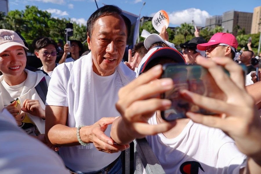 Supporters take a selfie with Terry Gou, the retired founder of major Apple supplier Foxconn, at a rally for legal reform and against high real estate prices in Taipei, Taiwan, on 16 July 2023. (Ann Wang/Reuters)