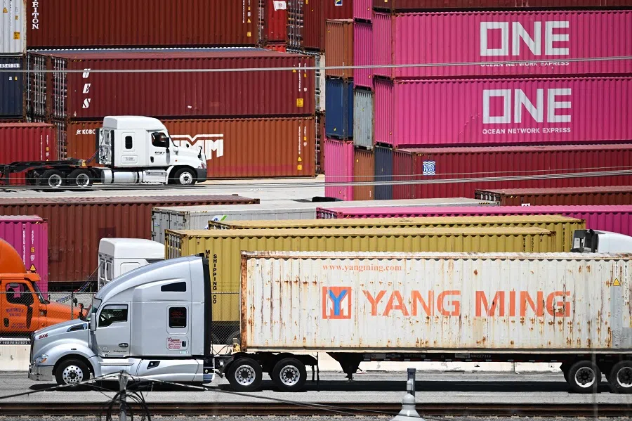 Trucks carry cargo shipping containers at the Port of Los Angeles in San Pedro, California on 10 April 2025. (Patrick T. Fallon/AFP)