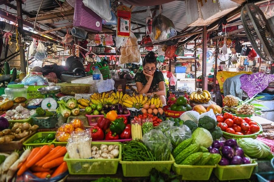 A vegetable vendor waits for customers at a market in Hanoi on 29 September 2020. (Nhac Nguyen/AFP)