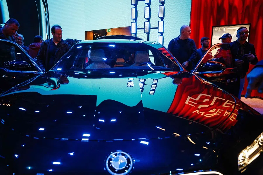 Visitors look at a BMW i7 xDrive electric car presented at the Paris Motor Show at Paris Expo, Porte de Versailles in Paris, France, on 15 October 2024. (Dimitar Dilkoff/AFP)