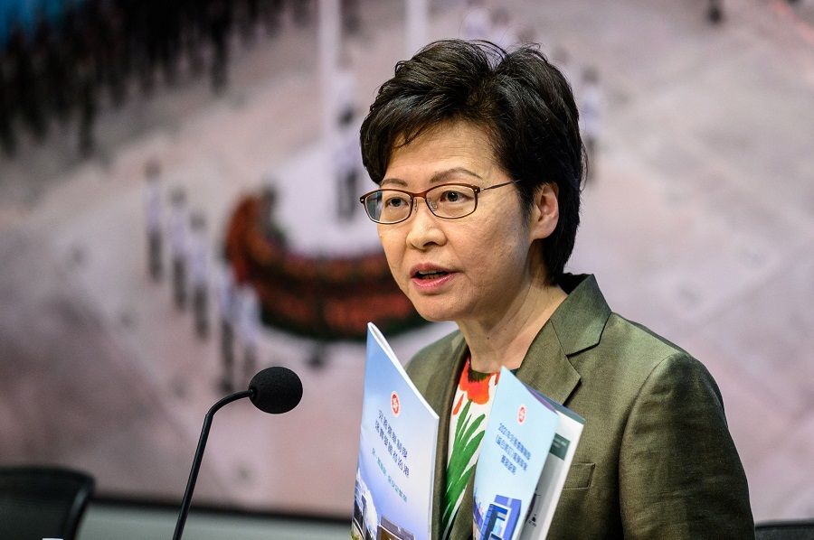 Hong Kong Chief Executive Carrie Lam holds a pamphlet on the "Improving Electoral System (Consolidated Amendments) Bill 2021" as she speaks during a press conference at the government headquarters in Hong Kong on 13 April 2021. (Anthony Wallace/AFP)