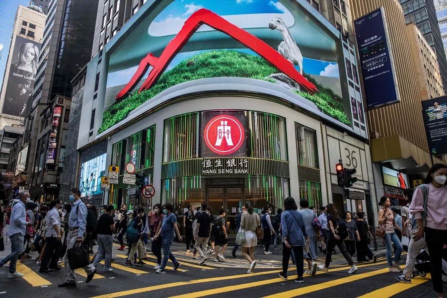 Pedestrians walk past a Hang Seng branch in Hong Kong, China, on 28 October 2022. (Isaac Lawrence/AFP)