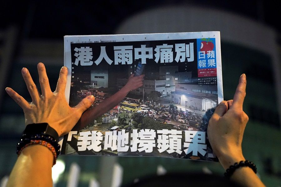 A supporter gestures while holding the final edition of Apple Daily in Hong Kong, China, 24 June 2021. (Lam Yik/Reuters)