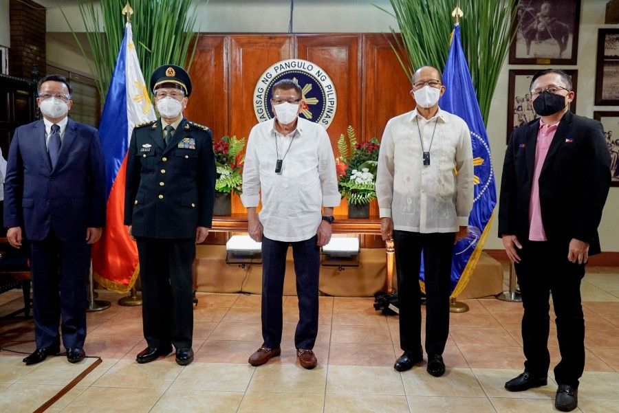This handout photo taken on 11 September shows Philippines President Rodrigo Duterte (C) posing for photos with Chinese Defense Minister Wei Fenghe (2L), Philippines Secretary of Defense Delfin Lorenzana (2R) and Senator Bong Go (R) at the Malacanang Palace, in Manila. (King Rodrigues/Presidential Photo Division/AFP)