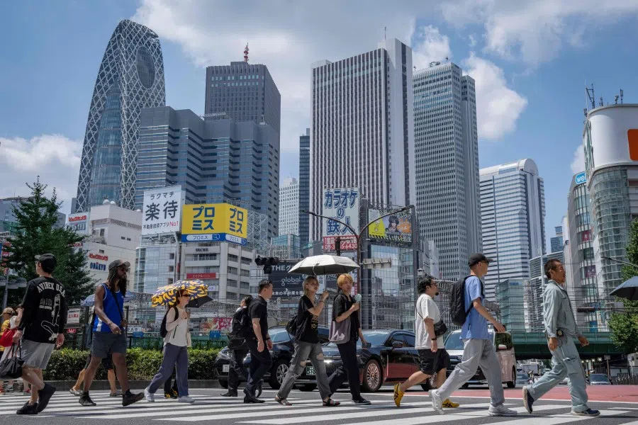 People cross a street at Shinjuku area in Tokyo, Japan on 25 August 2025.