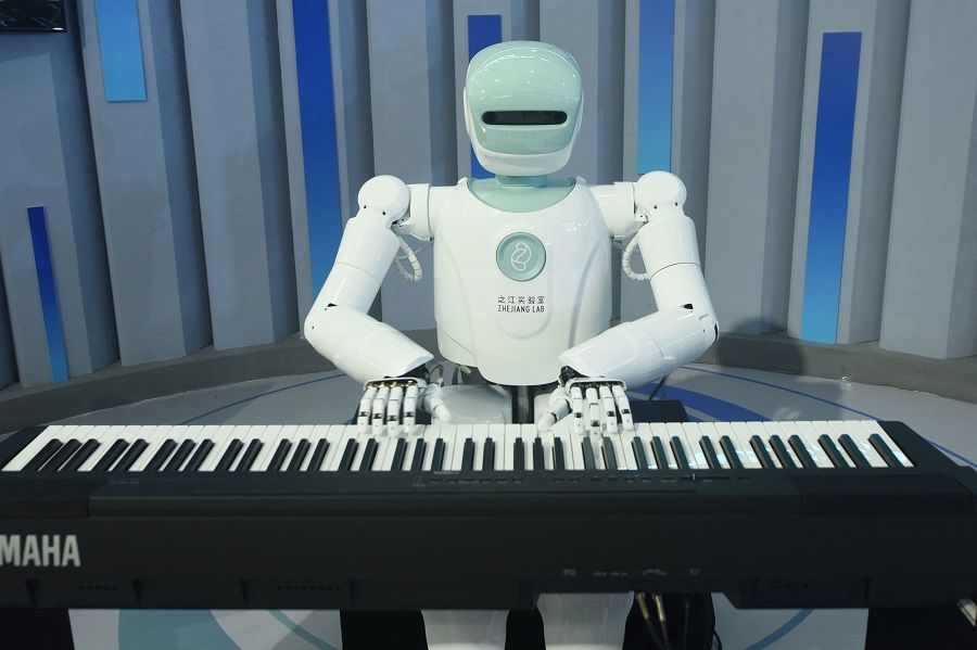 A robot plays the piano at the Apsara Conference, a cloud computing and artificial intelligence (AI) conference, in Hangzhou, Zhejiang province, China, on 19 October 2021. (STR/AFP)