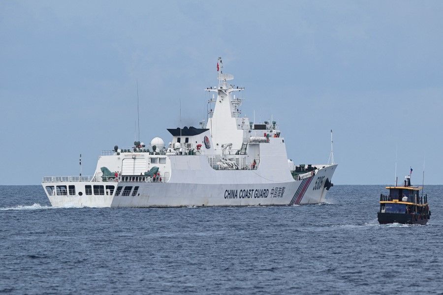 This photo taken on 22 August 2023 shows a Chinese coast guard ship (left) shadowing a Philippine civilian boat chartered by the Philippine navy to deliver supplies to Philippine navy ship BRP Sierra Madre in the disputed South China Sea. (Ted Aljibe/AFP)