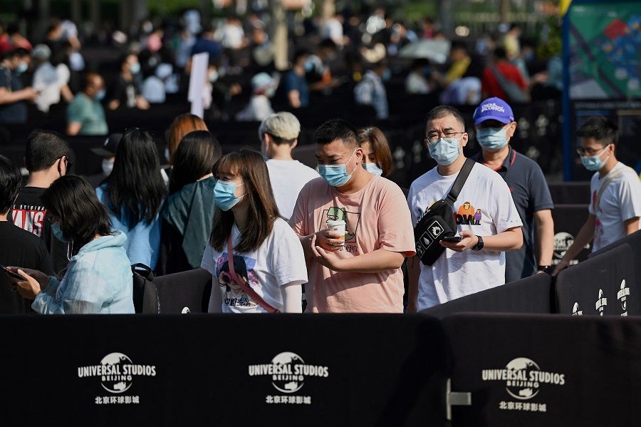 People queue to enter the Universal Studios Beijing theme park during an invitation-only test run in Beijing, China, on 1 September 2021, ahead of its opening on 20 September. (Noel Celis/AFP)