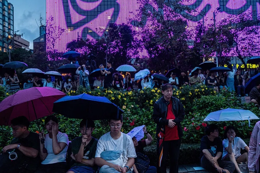 Tourists sit next to the habour at the Tsim Sha Tsui district during Labor Day holiday in Hong Kong, China, on 1 May 2024. (Lam Yik/Bloomberg)