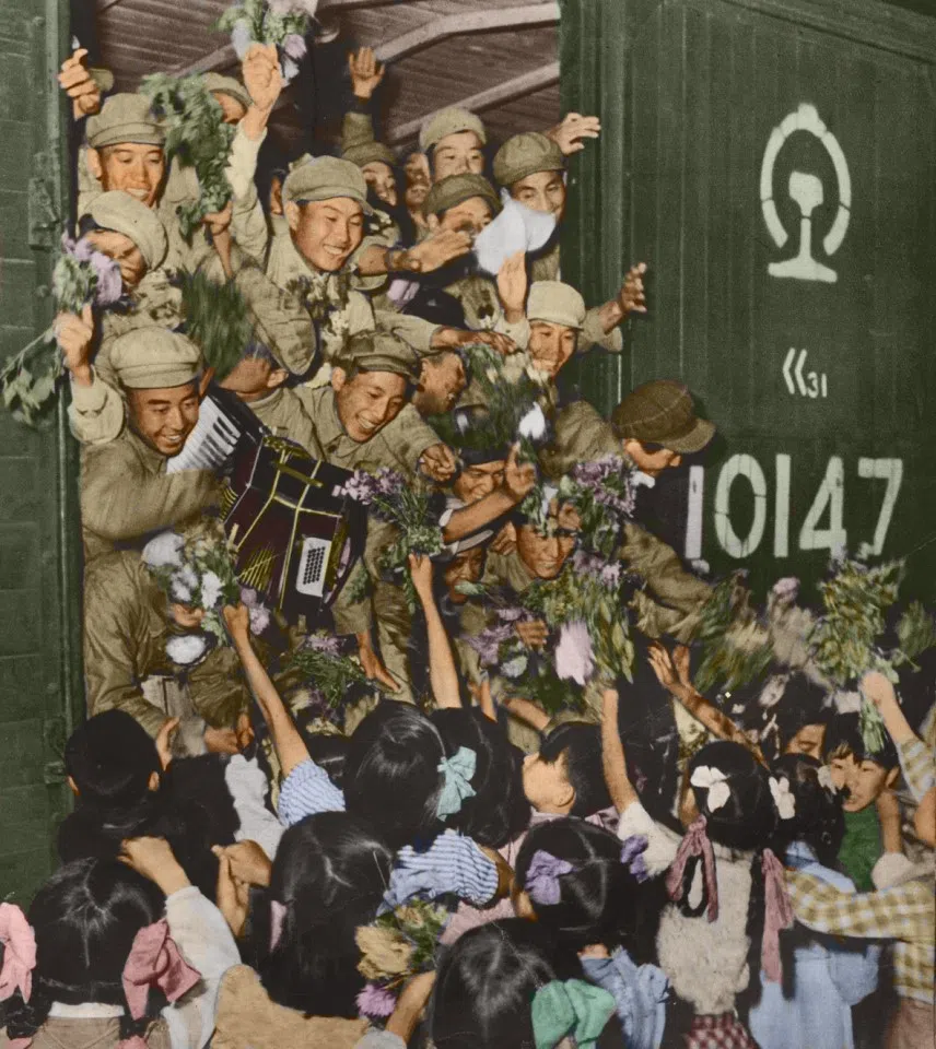 Volunteer troops who decided to return to China receiving a warm welcome from the people as they get off the train, 1953.
