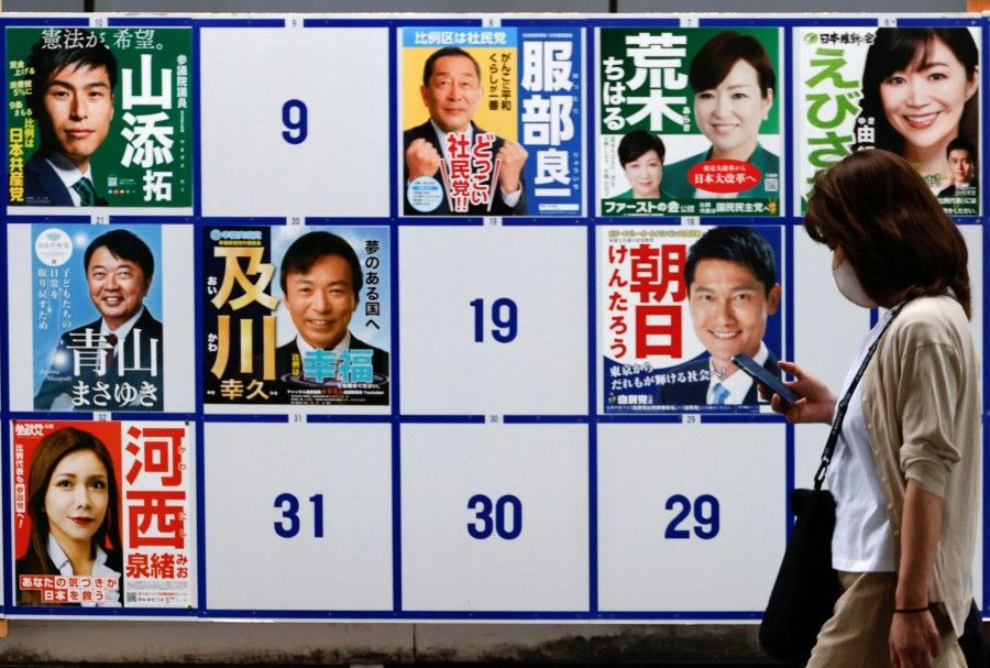 A woman walks past candidates' posters for the July 10, 2022 Upper House election in Tokyo, Japan, 22 June 2022. (Issei Kato/Reuters)
