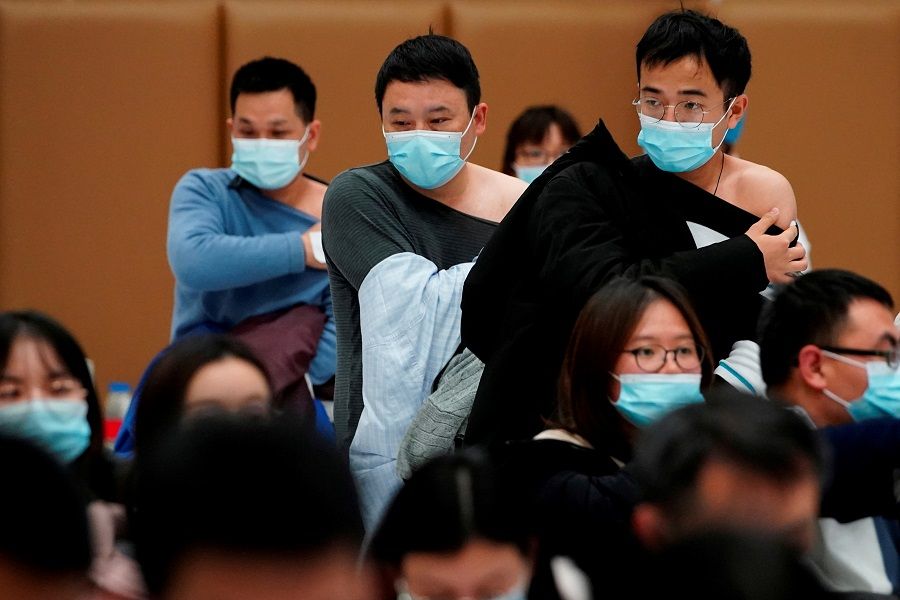 People stand at a vaccination site after receiving a dose of the Covid-19 vaccine, in Shanghai, China, 19 January 2021. (Aly Song/File Photo/Reuters)
