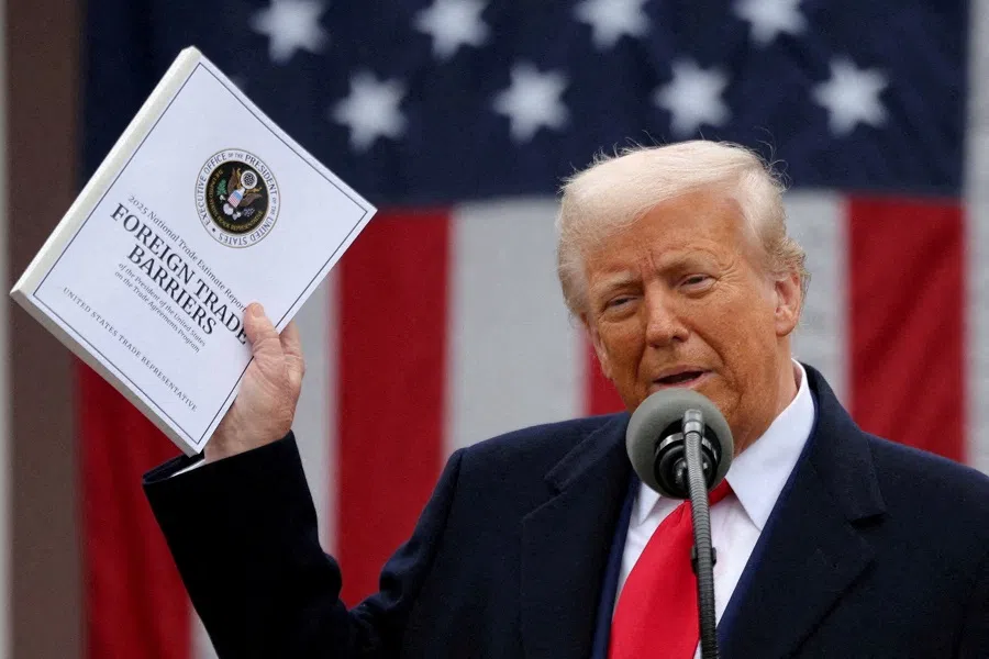 US President Donald Trump holds a “Foreign Trade Barriers” document as he delivers remarks on tariffs in the Rose Garden at the White House in Washington, DC, US, on 2 April 2025. (Carlos Barria/Reuters)