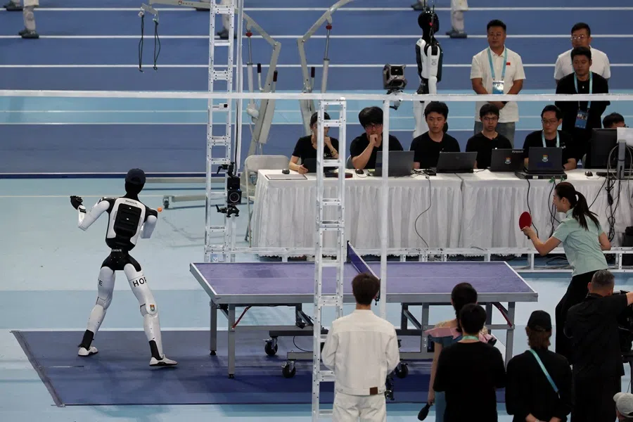 Smash, a humanoid robot developed by Kinetix AI and researchers from Hong Kong University, takes part in a table tennis exhibition match against Chinese former table tennis player Ding Ning, during the opening ceremony for the second World Humanoid Robot Games at the National Speed Skating Oval in Beijing, China, on 22 August 2026.