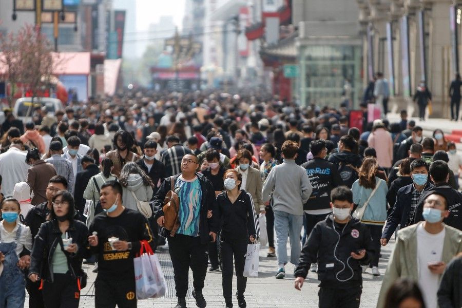 This photo taken on 4 May 2021 shows people visiting a business street in Shenyang, in China's Liaoning province. (STR/AFP)