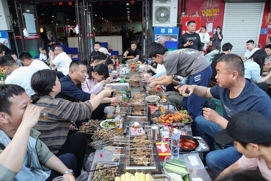 This photo taken on 2 May 2023 shows people eating barbecue in Zibo, Shandong province, China. (AFP)
