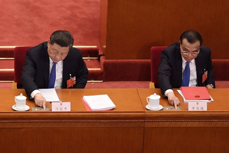 China's President Xi Jinping (L) and Premier Li Keqiang vote on a proposal to draft a Hong Kong security law during the closing session of the National People's Congress at the Great Hall of the People in Beijing, 28 May 2020. (Nicolas Asfouri/AFP)