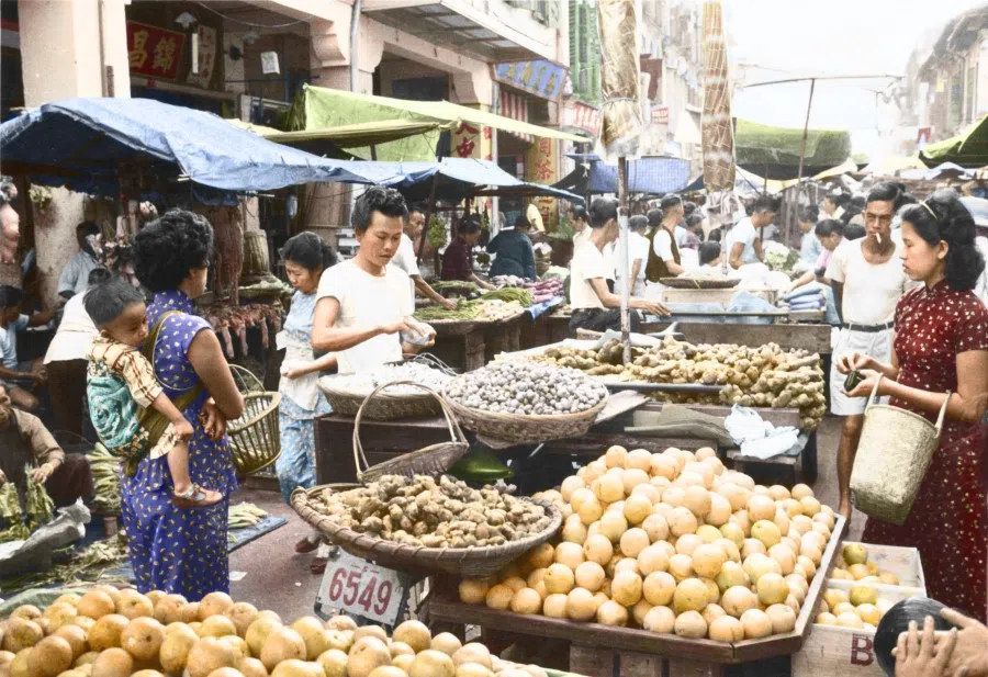 Women weave through a market in Singapore to select ingredients for preparing meals at home in the 1960s. The market is a convenient one-stop shop where vegetables, meats and spices could all be bought in one place.