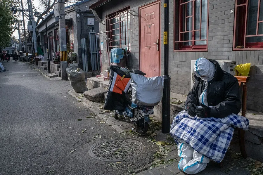A Covid-prevention worker guards residential buildings placed under lockdown in Beijing, China, on 29 November 2022. (Bloomberg)