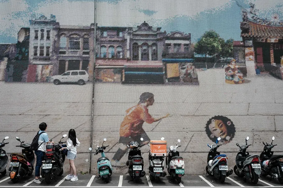 People look at a street graffiti in Taipei, Taiwan, on 26 May 2024. (Yasuyoshi Chiba/AFP)