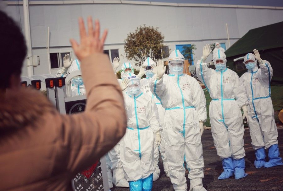Medical staff members wave to a recovered patient (foreground L) at Leishenshan Hospital in Wuhan. (AFP)