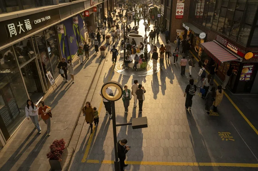 Shoppers pass stores in the Nanjing Road West shopping area in Shanghai, China, on 2 March 2025. (Raul Ariano/Bloomberg)
