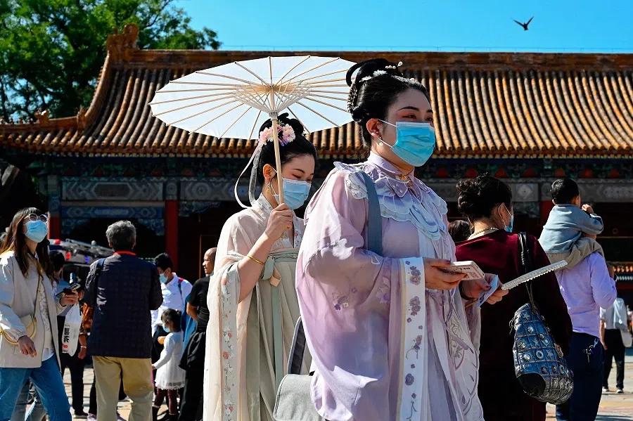 People wearing traditional Chinese costumes walk outside the Forbidden City during China's national day in Beijing, China, on 1 October 2021. (Jade Gao/AFP)