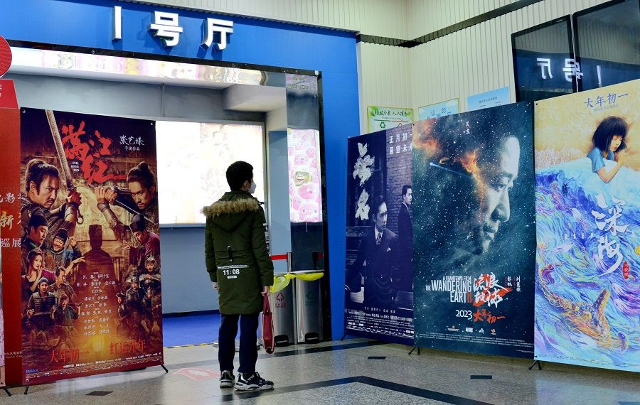 A person looks at publicity posters of Chinese films outside a cinema in Fuzhou, Fujian province, China, 25 January 2023. (CNS)