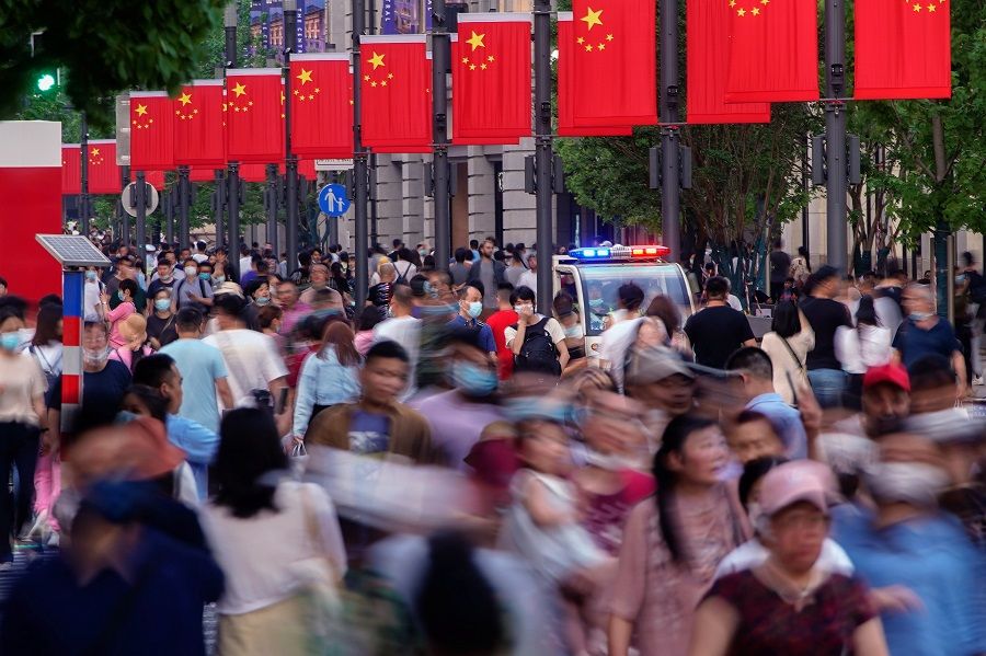 People walk along Nanjing Road, a main shopping area in Shanghai, China, 10 May 2021. (Aly Song/Reuters)