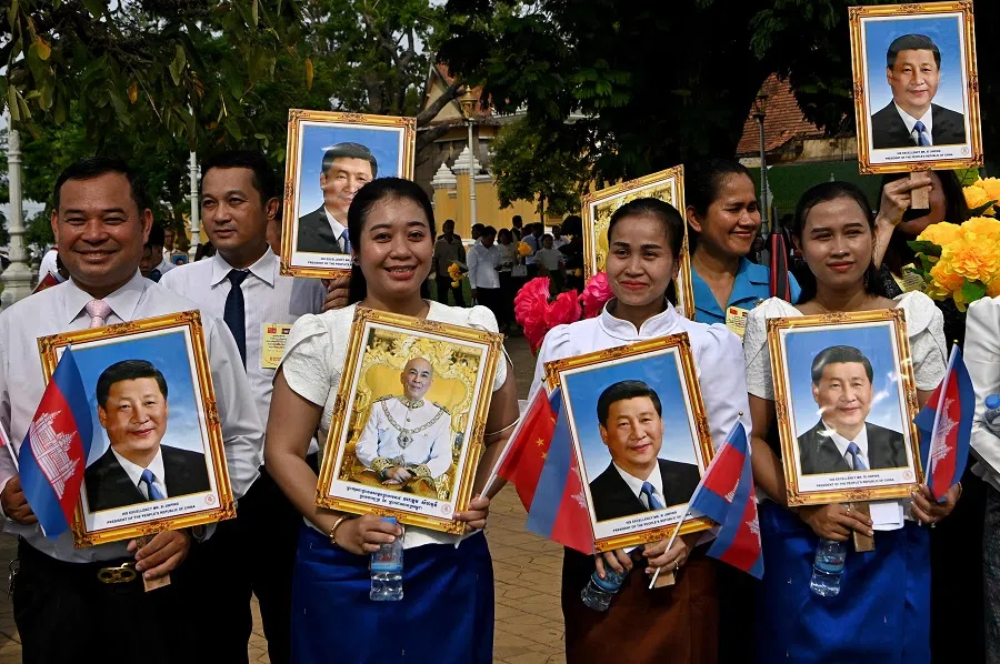 Cambodians hold portraits of China’s President Xi Jinping and Cambodia’s King Norodom Sihamoni during a welcome ceremony in front of the Royal Palace in Phnom Penh on 17 April 2025. (Tang Chhin Sothy/AFP)