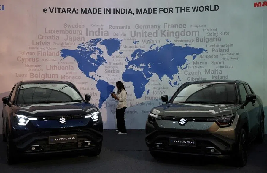 A visitor uses her phone next to Maruti Suzuki's e Vitara SUV at the company's Gujarat plant in the village of Hansalpur Becharaji, India, on 26 August 2025.