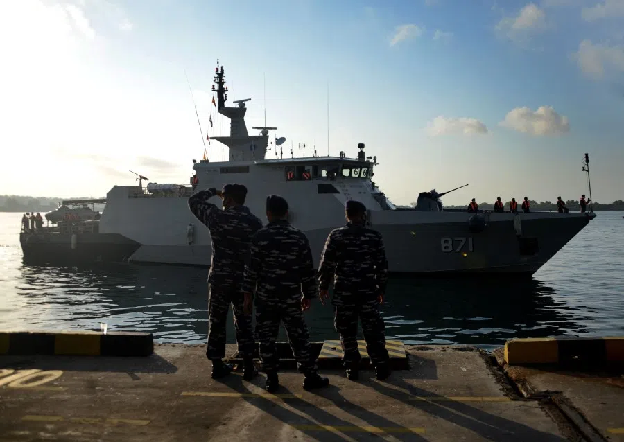 Indonesia navy soldiers look at Indonesian KRI Escolar ship arriving with crew members of a sunken fishing vessel at Benoa harbour in Denpasar, following their transfer from Australian navy ship HMAS Anzac to Indonesian KRI Escolar ship on 21 May 2021. (Sonny Tumbelaka/AFP)