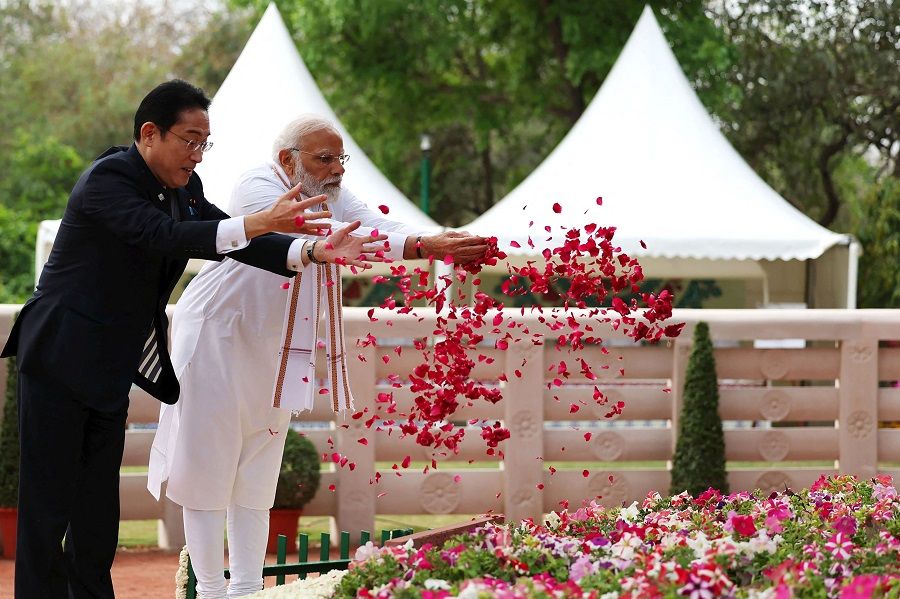 This handout photograph taken on 20 March 2023 and released by the Indian Press Information Bureau (PIB) shows Japan's Prime Minister Fumio Kishida (left) and his Indian counterpart Narendra Modi scattering rose petals at the holy Bodhi Tree during their visit at the Buddha Jayanti Park in New Delhi, India. (Indian Press Information Bureau/AFP)