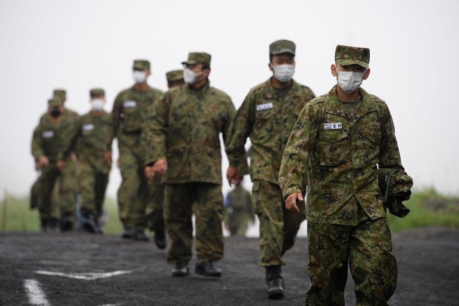 Japan's Ground Self-Defense Forces (JGSDF) soldiers wearing protective face masks arrive for a live fire exercise at JGSDF's training grounds in the East Fuji Maneuver Area in Gotemba, Japan, on 22 May 2021. A key part of US President Joe Bidens foreign policy has been turning to allies for support in addressing the security risks posed by the likes of China and North Korea, placing a greater emphasis on the Indo-Pacific region. (Akio Kon/Bloomberg)