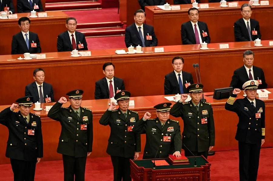 Zhang Youxia (front), newly-elected vice-chairman of the Central Military Commission (CMC) of the People's Republic of China, swears an oath with members of the CMC (left to right) Zhang Shengmin, Liu Zhenli, He Weidong, Li Shangfu and Miao Hua, as Chinese President Xi Jinping (top, centre) looks on, after they were elected during the fourth plenary session of the National People's Congress (NPC) at the Great Hall of the People in Beijing on 11 March 2023. (Greg Baker/Pool/AFP)
