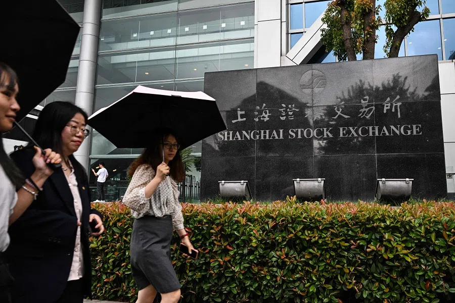People walk past the Shanghai Stock Exchange in the Pudong district in Shanghai, China, on 5 June 2024. (Hector Retamal/AFP)