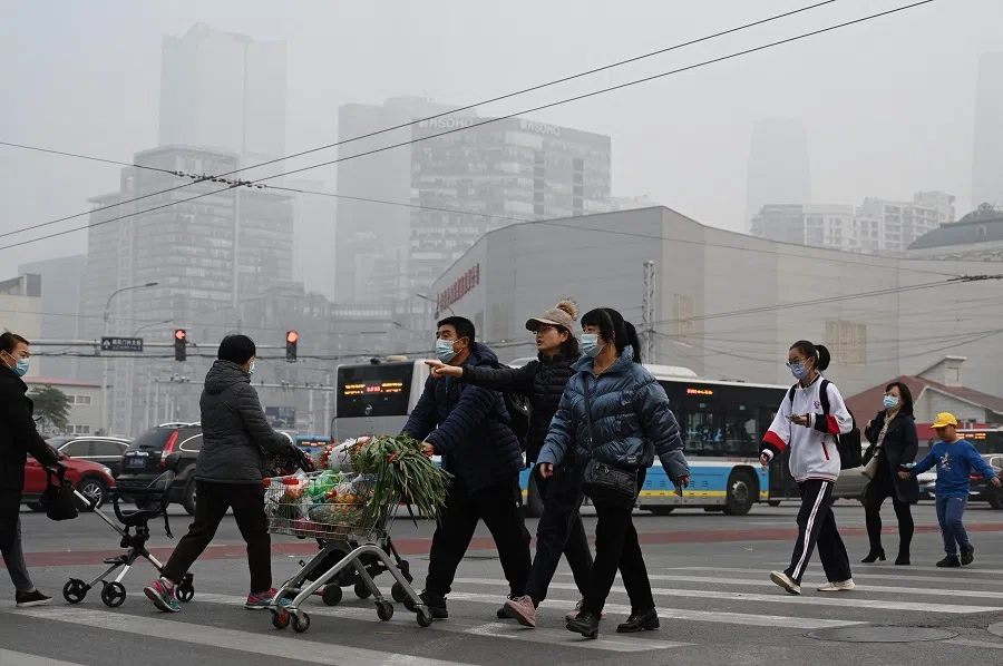 People cross a road in Beijing, China, on 5 November 2021. (Greg Baker/AFP)