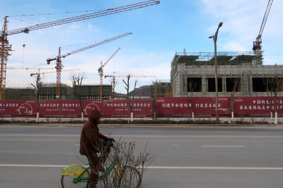 A man rides a bicycle past a Yango Group real estate project under construction in Yanan New Zone, Shaanxi province, China, 4 January 2019. (Yawen Chen/Reuters)