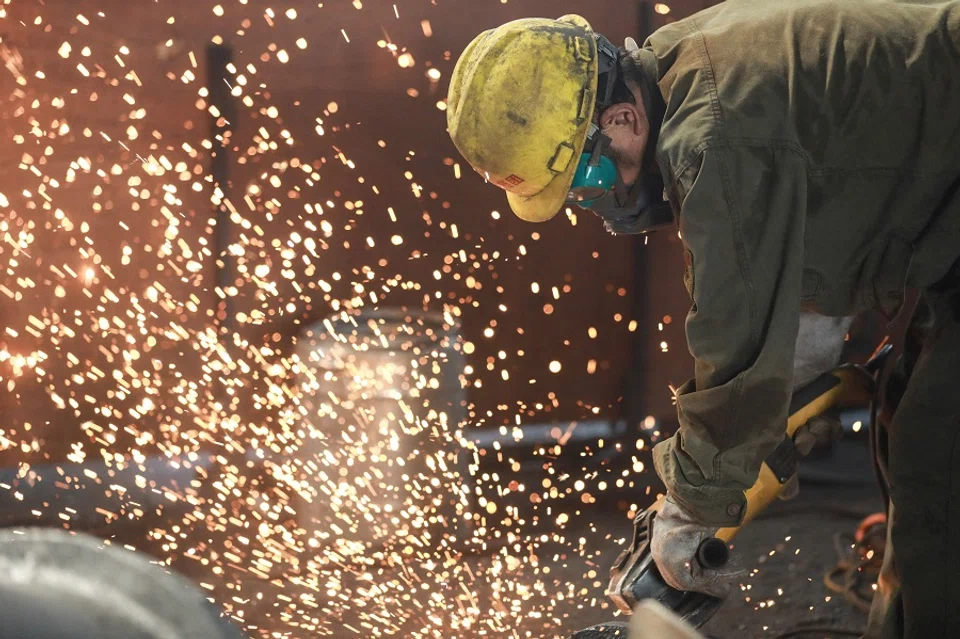 A worker welding metal at a factory in Hangzhou in China's eastern Zhejiang province, on 15 July 2023. (AFP)