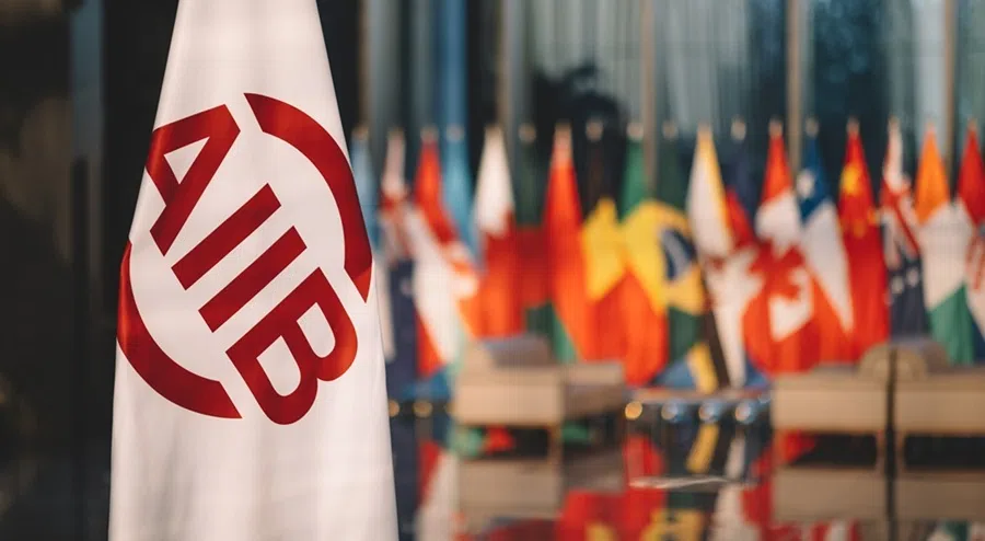 The logo flag of the Asian Infrastructure Investment Bank (AIIB) with member state flags lined up in the background.