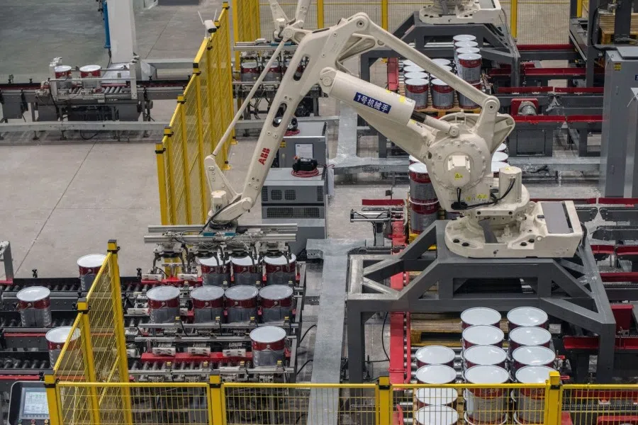 Robotic arms move buckets of paint at the Nippon Paint Ltd. plant in Qingyuan, Guangdong Province, China, on 10 May 2023. (Bloomberg)