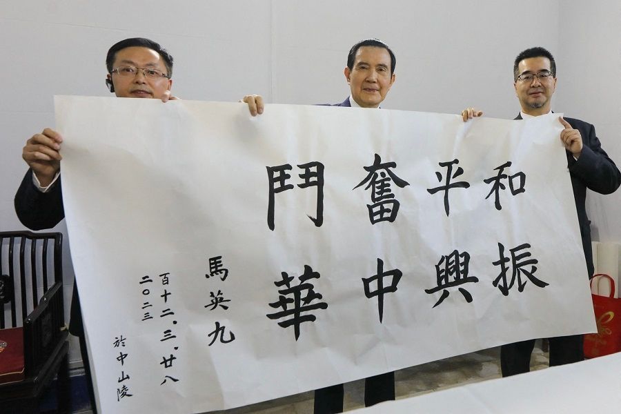 This handout picture taken and released by the office of former Taiwanese President Ma Ying-jeou on 28 March 2023 shows former Taiwanese President Ma Ying-jeou (centre) holding a written calligraphy reading "Peaceful struggle and revitalisation of Zhonghua" during his visit to the Sun Yat-sen Mausoleum in Nanjing, Jiangsu province, China. (Handout/Ma Ying-jeou's office/AFP)