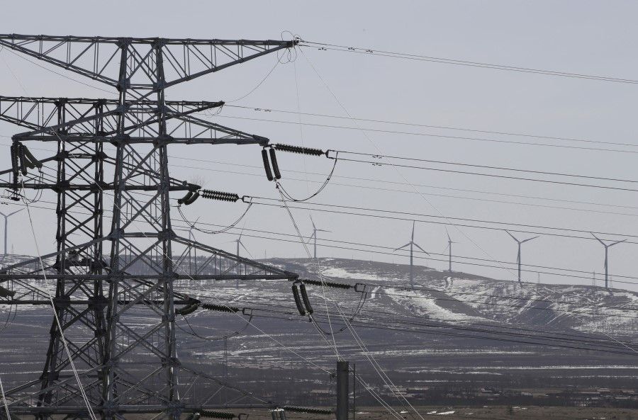Power lines and wind turbines are pictured at a wind and solar energy storage and transmission power station of the State Grid Corporation of China in Zhangjiakou of Hebei province, China on 18 March 2016. (Jason Lee/Reuters)