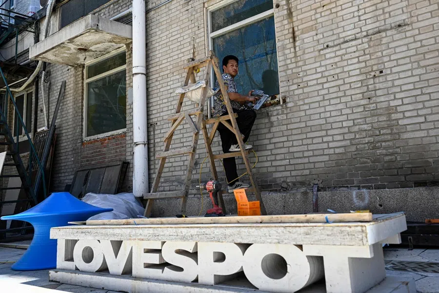 A worker is seen at a construction site at a commercial district in Beijing on 30 July 2025. (Jade Gao/AFP)