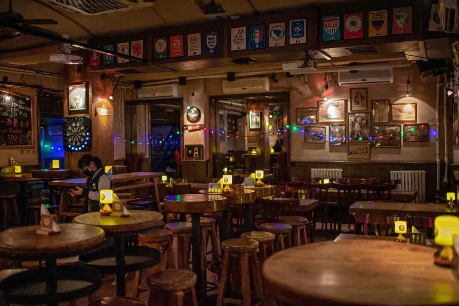 A bar in Beijing is empty except for a staff member, 29 January 2020. (Nicolas Asfouri/AFP)