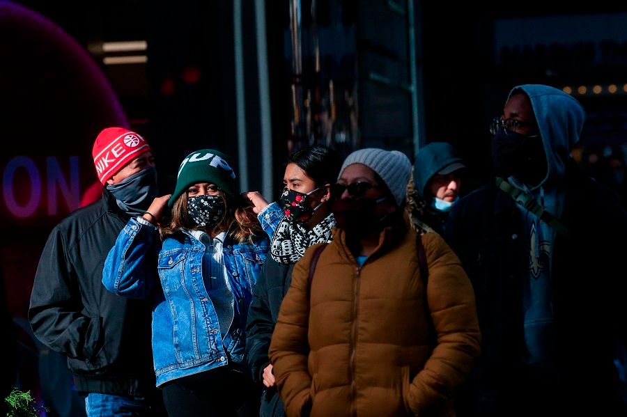 People wear face masks as they walk in Times Square in New York on 10 December 2020. (Kena Betancur/AFP)